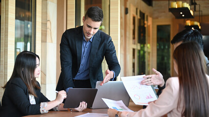 Professional business people discussing corporation project planning at meeting table in boardroom.