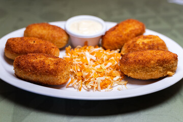 Dish with croquettes served with mayonnaise sauce and vegetables