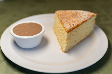 Portion of santiago cake served with chocolate sauce