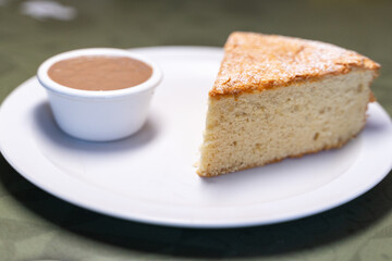 Portion of santiago cake served with chocolate cream