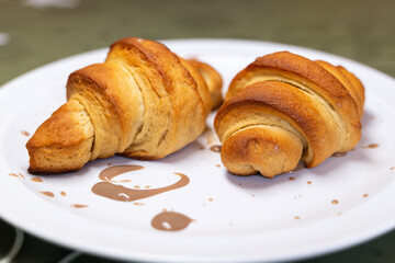 Plate with a pair of croissants decorated with chocolate cream