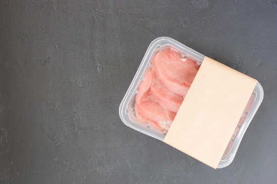 Raw Steak, Entrecote In Plastic Vacuum Packaging On A Black Background. Logo Layout Design.