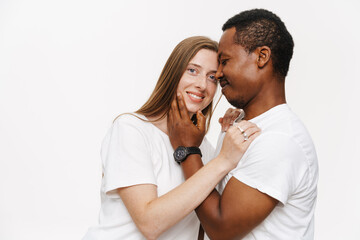 Smiling mid aged diverse casual couple embracing