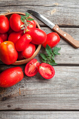 Fresh tomatoes in a bowl on a wooden background