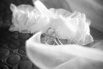 bridal garter for stockings with two silver hearts. Black and white monochrome picture. Wedding clothing element. Wallpaper picture. Love anniversary invitation. Preparation for party