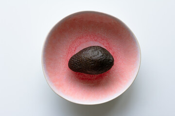 closed avocado on a pink plate