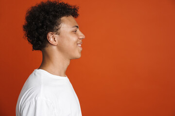 Young black man in t-shirt laughing while looking aside