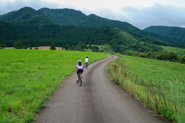 Naklejka premium 高原のサイクリングロードで自転車に乗るキッズ