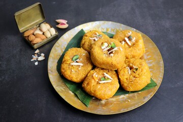 Indian traditional sweet balushahi served on a metal plate over black background. Also known as Balsaahi, badushah is a sweet food served on a Brass plate over moody background. Copy space.