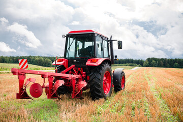 tractor with a large plow is ready to work in the field