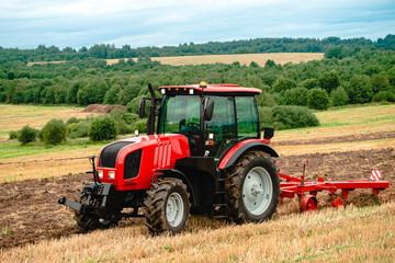 Naklejka premium Farmer in tractor plowing the land in autumn