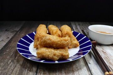 Pile of deep fried tofu sheet wrapped with fresh shrimp serving on the plate. Famous dim sum menu in Asia restaurant. 