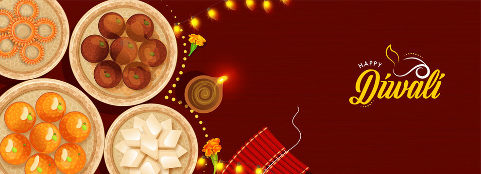 Top View Of Presenting Indian Sweets With Lit Oil Lamp (Diya), Firecracker Stripe And Lighting Garland On Red Background For Happy Diwali Celebration.