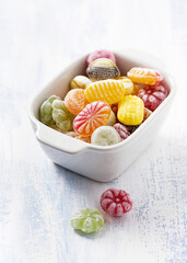 Bowl filled with colorful sweet candies in white ceramic bowl. Selective focus.