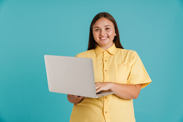 Obraz premium Young white woman wearing shirt smiling and using laptop