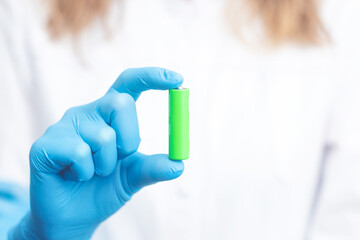 scientist holding a lithium battery. green energy concept.