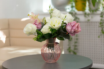 artificial flowers on a glass bottle, a bouquet of silk flowers on a black table