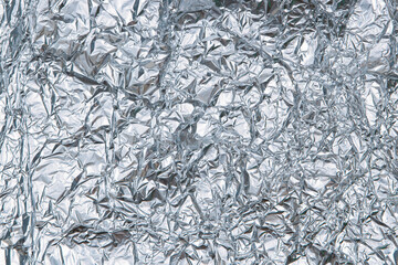 Silver shiny crumpled foil texture background. Top view