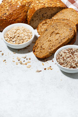 fresh bread with oatmeal and seeds, cut into slices, vertical