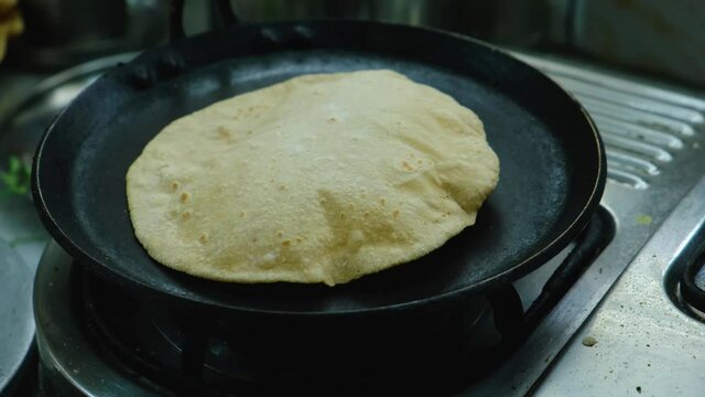 Preparing Roti ( Chapati , an Indian bread ) on a hot pan.