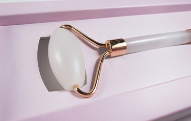 White massage quartz roller for the face close-up in pink gift box