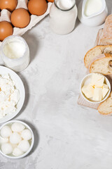 fresh farm dairy products and bread on white background, top view, vertical