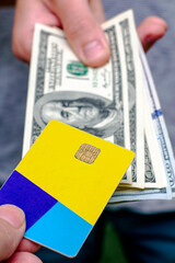 a man holds a stack of hundred dollar bills in his hand and exchanges them for a credit card