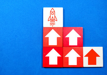 Colored cubes with up arrow and rocket start. The concepts of startups, income and success.