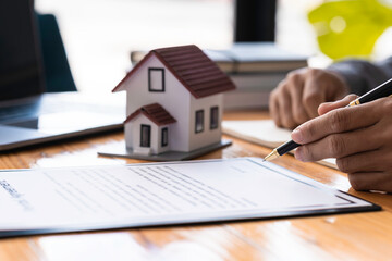 Rental agreement, Real estate agent working sign agreement document contract for home loan insurance approving purchases for client with house model and key on wooden desk
