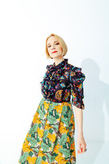 Stylish woman in bright outfit posing in photo studio
