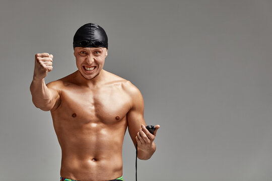 Excited swimer with stopwatch standing on gray background. New record. Motivation, advertising banner, place for text