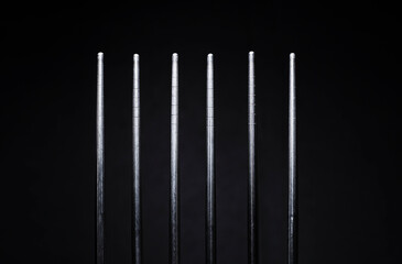 Stainless steel chopsticks on black background.