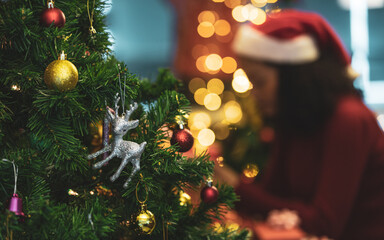 Lovely silver reindeer doll and beautiful ornament ball hang on Christmas tree as Santa decoration for shiny night party at home in winter holiday festival