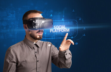 Businessman looking through Virtual Reality glasses, social media concept