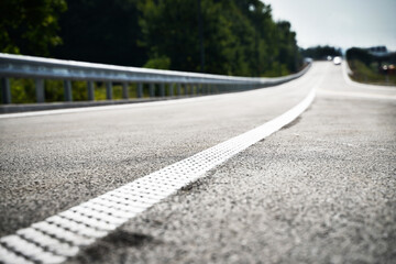 Fototapeta premium White highway safety line up close safety rumble strips line made of dots on road