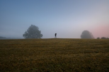 Naklejka na ściany i meble photographer man in sunrise fog