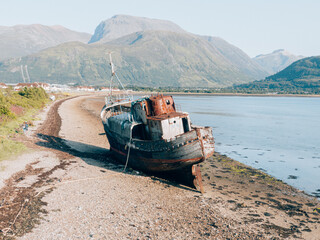 A boat stranded in the loch Linnhe on Fort William, on the center of Scottish Highlands, Ben Nevis...