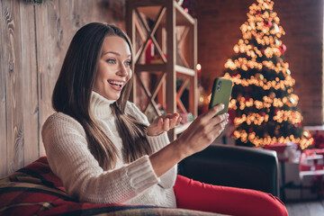 Photo of shiny cute young lady wear white pullover smiling talking modern device indoors house home room