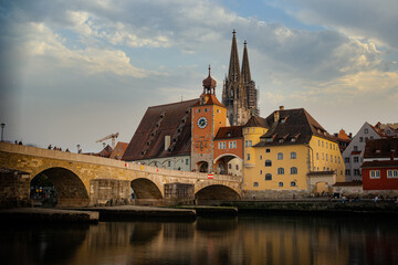 View from the Danube on the Regensburg Cathedral and Stone Bridge with lights in Regensburg in the...