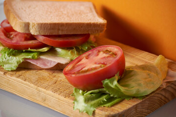 Healthy sandwich with tomato in orange background