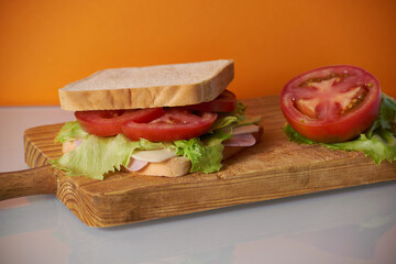 Healthy sandwich with tomato in orange background