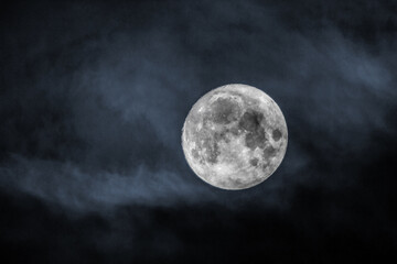Picture of the full moon with clouds on black sky