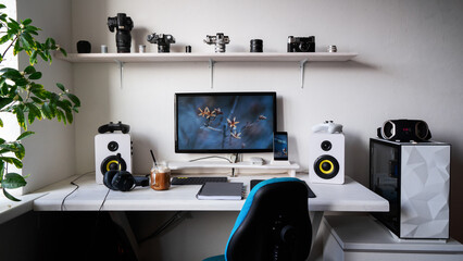 Front view comfortable home office workplace of photographer with computer, camera lens © Aboltin