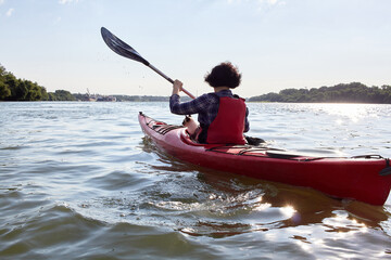 Woman with cat (Mekong bobtail (siames) enjoys kayaking in the river at the summer morning in nature