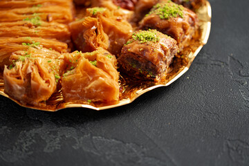 Delicious baklava dessert in oriental setting on black background