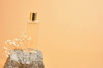 gypsophila flower, perfume bottle and natural stone on beige background