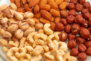 Assortment of dry nuts on glass plate, close up