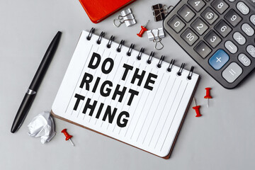 The words Do the right thing written on a white notebook. Closeup of a personal agenda. Top view. Office concept