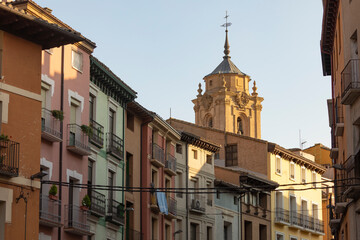 View of the tower and bell tower of the Basilica of San Lorenzo, and the houses that surround it, in the city of Huesca, Spain, from Coso Bajo street