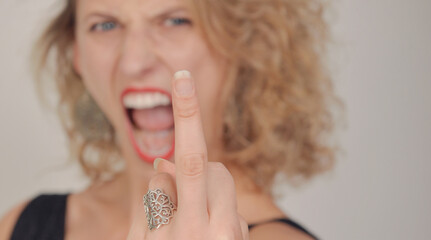 frau zeigt stinkefinge rund schreit laut blonde haare portrait emotional laut